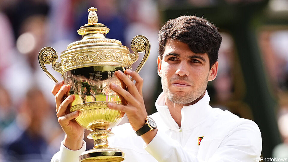 Carlos Alcaraz toont zijn trofee na zijn tweede opeenvolgende eindzege op Wimbledon.